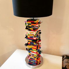 a lamp made out of legos sitting on top of a white table next to a wall