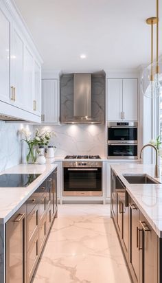 a kitchen with marble counter tops and stainless steel appliances, along with white cabinetry