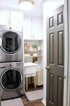 a washer and dryer in a small room next to a door that leads into a kitchen