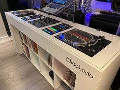 a dj's desk with two turntables and laptop on the top shelf