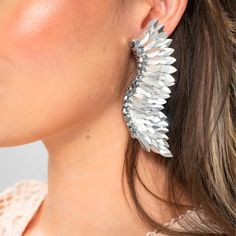 The Silver Statement Wing Earrings are the perfect accessory for those who want to make a bold statement with their jewelry. The wings symbolize freedom and lightness, and these earrings capture that essence in their unique design. The handmade sequins shimmer in the light, catching the eye and adding a touch of glamour to any outfit. These silver wing earrings are perfect for any occasion, from a night out with friends to a formal event. Add these stunning earrings to your collection and elevat Trendy Pierced Crystal Earrings For Party, Metal Wrap Drop Earrings For Party, Pierced Drop Wrap Earrings For Party, Metal Wrap Earrings For Party, Trendy Pierced Wrap Earrings For Party, Glamorous Pierced Crystal Earrings For Party, Glamorous Pierced Crystal Party Earrings, Trendy Wrap Drop Earrings For Party, Trendy Party Wrap Earrings