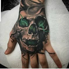 a hand with a skull and green eyes on it