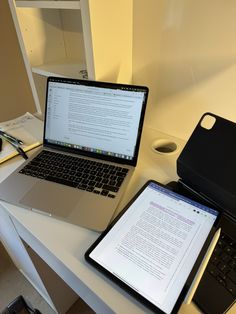 two laptops sitting on top of a white desk