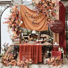 the table is set up with an orange and red cloth draped over it that says cake home