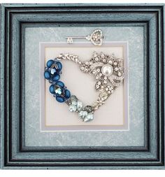 a blue frame holds a beaded bracelet and broochet in the shape of a heart