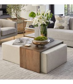 a living room filled with furniture and flowers on top of a coffee table in front of a couch