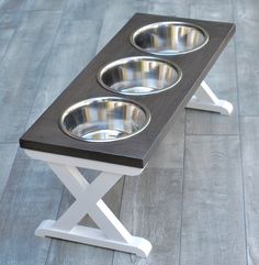 the elevated dog bowl stand has three bowls on it