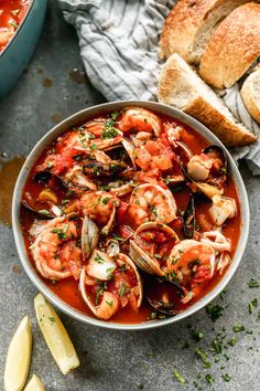 a bowl of seafood stew with bread on the side