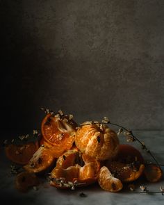 some peeled oranges sitting on top of each other in front of a gray background