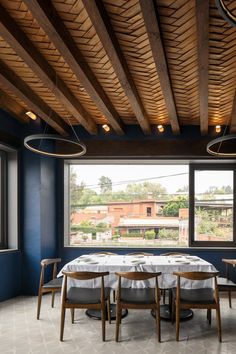 a dining room with blue walls and wooden ceiling