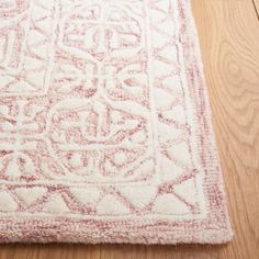 a white and red rug on top of a wooden floor