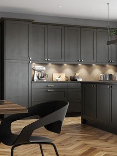 a modern kitchen with wooden floors and dark gray cabinetry, along with an island