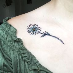 a woman's chest with a flower tattoo on the left side of her neck