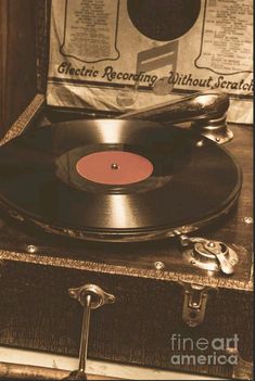 an old record player sitting on top of a suitcase