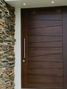 a wooden door in front of a stone wall