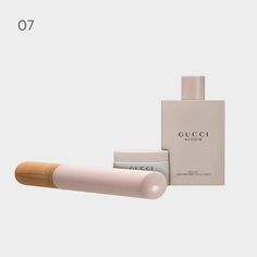 a bottle of perfume next to a tube of lotion on a white background with the words gucci bloom written below it