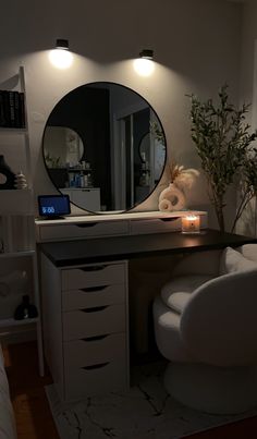 a white chair sitting in front of a desk with a mirror on top of it