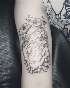 a black and white photo of a woman with flowers on her arm