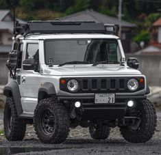 a white jeep parked on top of a gravel road