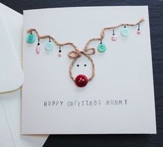 a christmas card with a reindeer's head on it and some beads hanging from the string