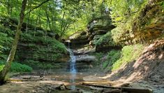 a small waterfall in the middle of a forest