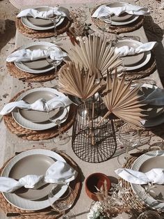 a table set with plates and napkins on it, next to a wicker basket