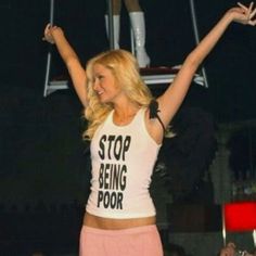 a woman standing on top of a pole with her arms in the air