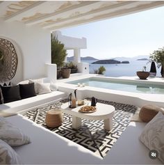 a living room with white furniture and an outdoor swimming pool next to the water's edge