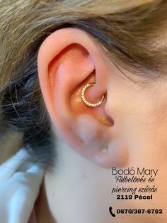 a woman with an ear piercing in gold