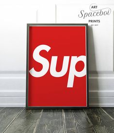 a red poster with the word sup on it in front of a white wall