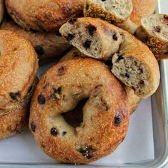 blueberry bagels are piled on top of each other in a metal tray, ready to be eaten