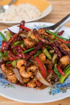 a plate full of stir fry with vegetables and meat on it, next to rice