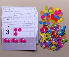 this is an image of a counting game with cars and balloons on the table next to it