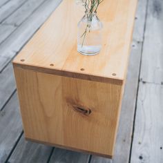 a vase filled with flowers sitting on top of a wooden table