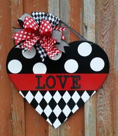 a heart shaped door hanger with the word love painted on it