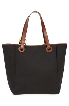 An oversized curb-chain link anchors one of the top handles of this versatile tote that's crafted from canvas and trimmed in contrast leather. Magnetic-snap closure Top carry handles Interior wall pocket Structured silhouette with flat base for stability Lined Textile with leather trim Imported Designer Handbags Everyday Canvas Bag With Metal Hardware, Canvas Bags With Metal Hardware For Daily Use, Everyday Canvas Bags With Metal Hardware, Classic Canvas Shoulder Bag With Gold-tone Hardware, Canvas Shoulder Bag With Top Handle And Branded Hardware, Canvas Double Handle Bag With Branded Hardware, Canvas Bag With Branded Hardware And Double Handles, Canvas Bag With Double Handle And Branded Hardware, Workwear Bag With Canvas Lining And Double Handle