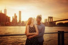 a man and woman standing next to each other near the water