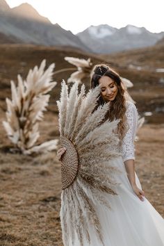 a woman in a white dress holding a large feather