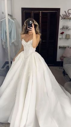 a woman is taking a selfie in her wedding dress while she takes a photo