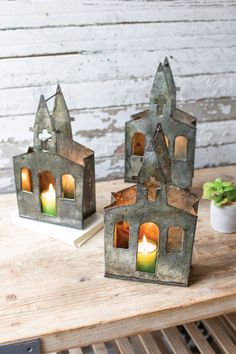 three lit candles sitting on top of a wooden table