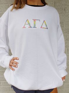 This sweatshirt features elegant Greek floral font embroidery designed in spring and pastel shades. We're confident this design will quickly become a favorite in your wardrobe!  Garment Information *Offered on white only *Greek letters are embroidered, and colors cannot be changed * Unisex fit (Made to fit male or female) * Crewneck and hooded sweatshirts 50/50 poly-cotton blend * Brands used: Port & Company, Gildan, and Jerzee (depending on availability) Font Embroidery, Floral Font, Alpha Gamma Delta, Sigma Kappa, Kappa Delta, Greek Letters, Memphis Tn, Pastel Shades, 50 50