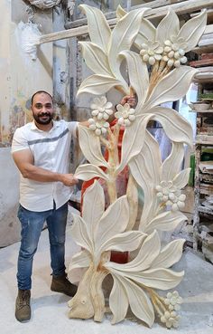 a man standing next to a white sculpture