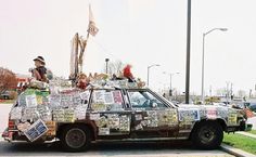 an old car covered in newspapers and pictures