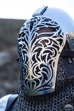 a close up of a person wearing a metal helmet