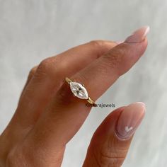 a woman's hand with a diamond ring on top of her finger, showing the side view