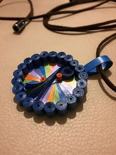 a necklace made out of plastic beads on a leather surface with a cord attached to it