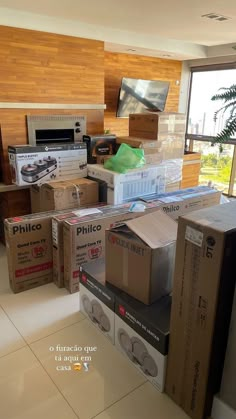 boxes are stacked on top of each other in the middle of a room filled with appliances