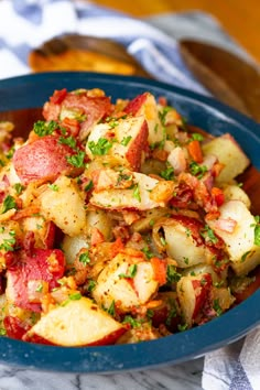 a blue bowl filled with potatoes and bacon