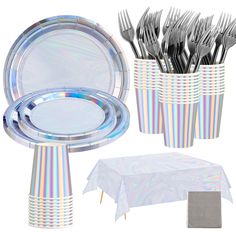 a table setting with silverware, plates and napkins in striped cup vases