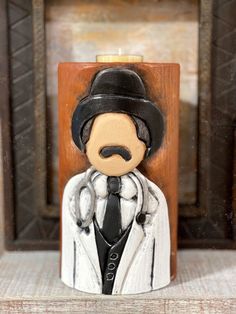 a wooden sculpture of a man wearing a suit and tie with a hat on his head